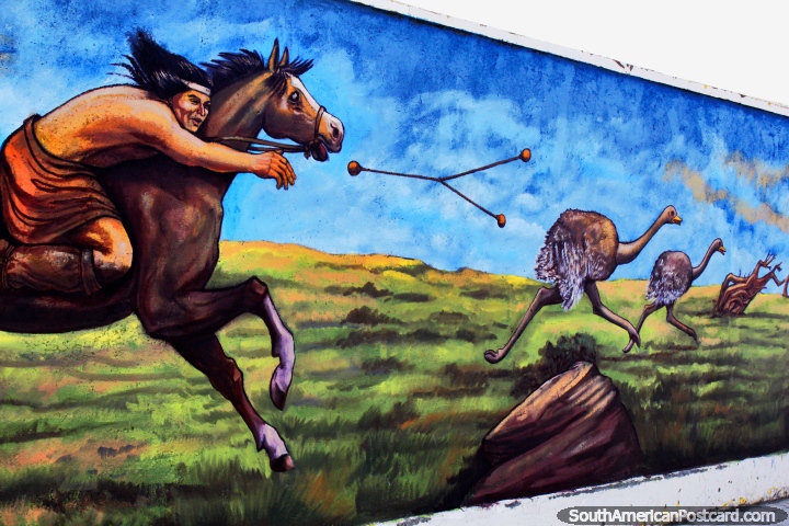 A dangerous weapon thrown to kill the emus by an indigenous man on horseback, mural by Eladio Godoy Vera in Puerto Natales. (720x480px). Chile, South America.
