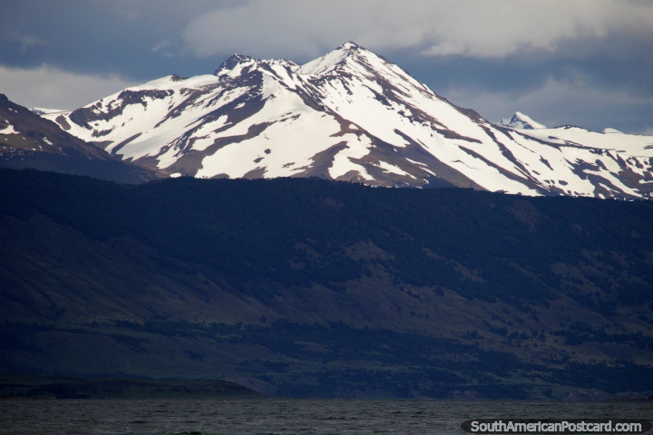Enormes montanhas cobertas de neve no horizonte em volta das guas em Porto Natales. (720x480px). Chile, Amrica do Sul.