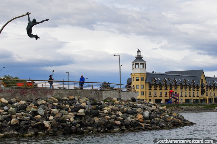 Seafront in Puerto Natales, hotel with a tower, rocks and a monument. (720x480px). Chile, South America.