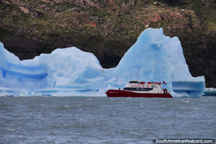 Uns cruzeiros de barco em volta de um enorme iceberg em Geleira Cinza em parque nacional Torres do Paine. (720x480px). Chile, Amrica do Sul.