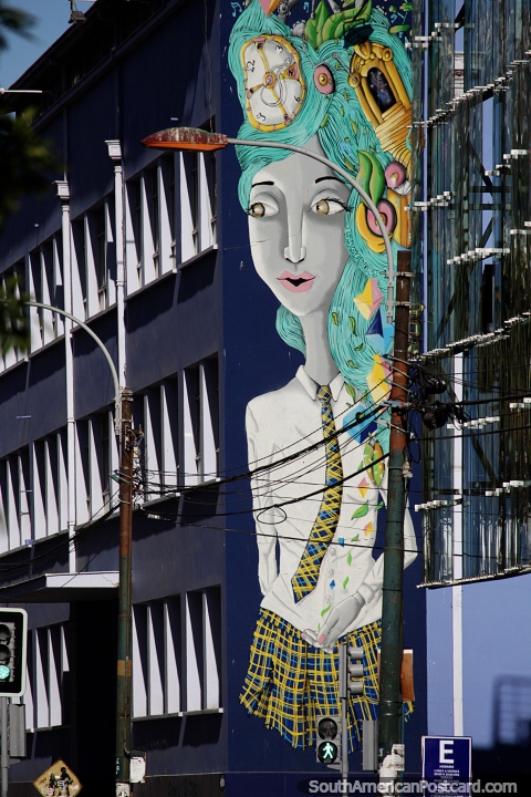 A aluna gigantesca pintou sobre um lado de edifïcio em Valparaïso, cabelo verde e cara de relógio. (480x720px). Chile, América do Sul.