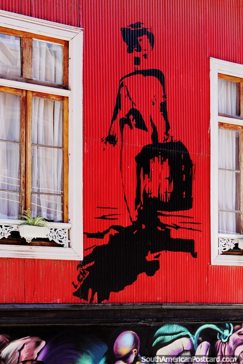 Homem com uma mala de viagem, uma imagem preta pintou em um edifcio de ferro ondulado vermelho em Valparaso. (480x720px). Chile, Amrica do Sul.