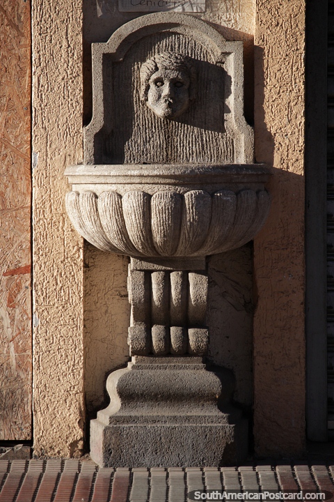 Stone basin with a face, part of a building facade in La Serena. (480x720px). Chile, South America.
