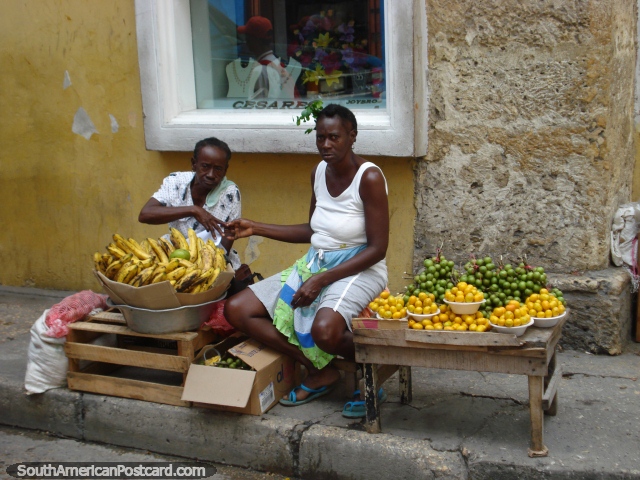 2 women sell bananas, mamones and ciruelas on the street in Cartagena. (640x480px). Colombia, South America.