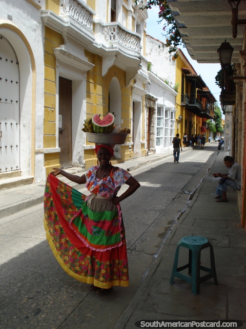 A woman carries fruit on her head in Cartagena. (480x640px). Colombia, South America.