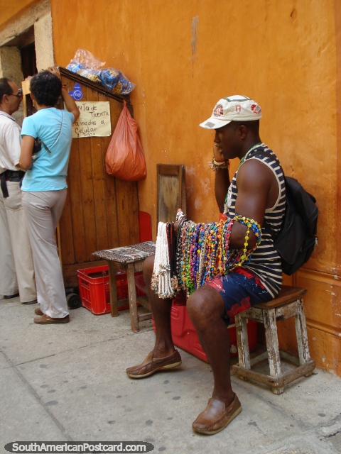 Homem que vende jóias coloridas na rua em Cartagena. (480x640px). Colômbia, América do Sul.