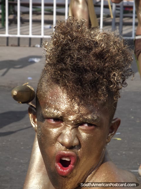 Warrior with gold hair and face poses with spear at Barranquilla Carnival. (480x640px). Colombia, South America.