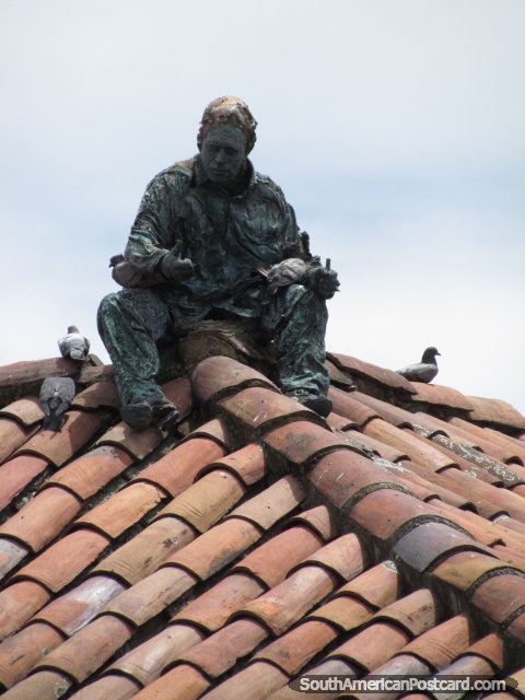 Escultura de homem que se senta em um telhado coberto com telhas em esquina de Praça Bolivar em Bogotá. (480x640px). Colômbia, América do Sul.