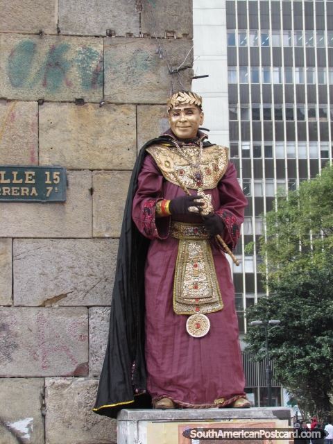 Street artist in Bogota with gold face dressed in crimson robes. (480x640px). Colombia, South America.