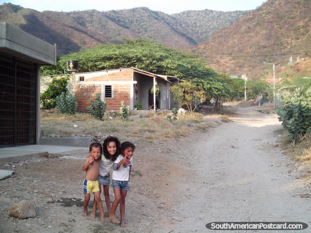 Trs crianas locais de Taganga comem pirulitos nas ruas de trs. (640x480px). Colmbia, Amrica do Sul.