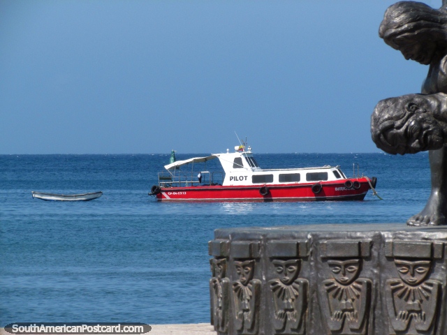 Visão de um barco de junto de um monumento na terra a margem de água de Santa Marta. (640x480px). Colômbia, América do Sul.