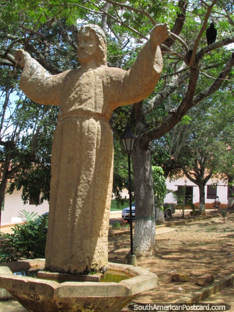 Estatua de Jesús con buitre negro en árbol detrás en parque en Barichara. (480x640px). Colombia, Sudamerica.