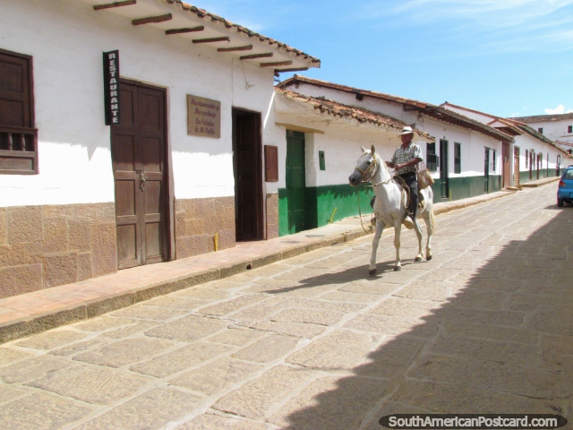 Man on horseback rides down the street in Barichara. (640x480px). Colombia, South America.