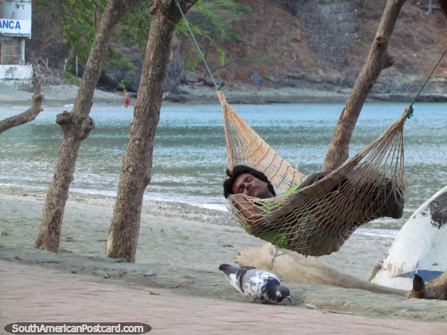 Man sleeps in a hammock beside the beach at dawn in Taganga. (640x480px). Colombia, South America.