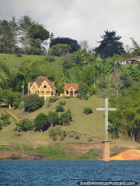 El aspecto a través de la laguna a la cruz que marca el área original de la ciudad de Penol. (480x640px). Colombia, Sudamerica.