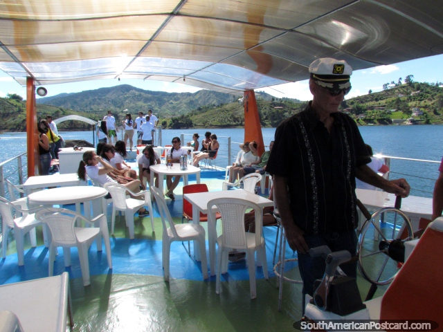 El Capitn Richard al timn que toma a la gente que hace un crucero alrededor de la laguna en Penol. (640x480px). Colombia, Sudamerica.