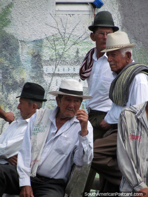 A group of men in hats and smart white shirts in Penol on Sunday. (480x640px). Colombia, South America.