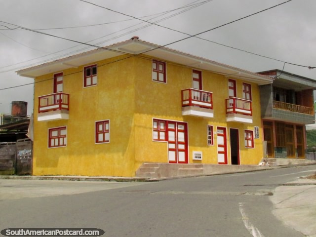 Un edificio de color amarillo con puertas, ventanas y balcones rojas y blancas, entre Quimbaya y Salento. (640x480px). Colombia, Sudamerica.