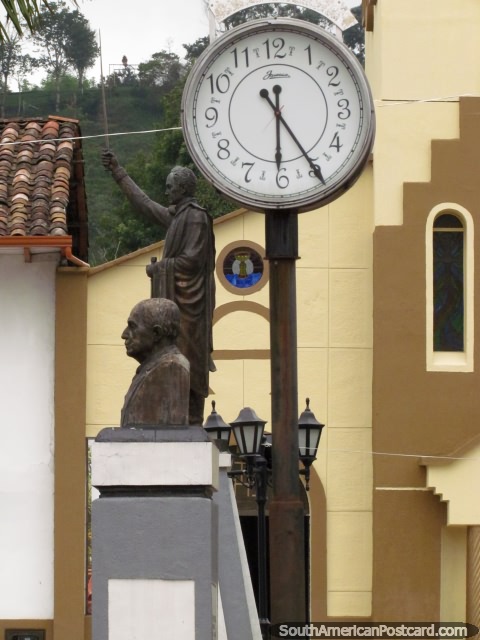 Clock-face, Bolivar statue and bust at the plaza in Salento. (480x640px). Colombia, South America.