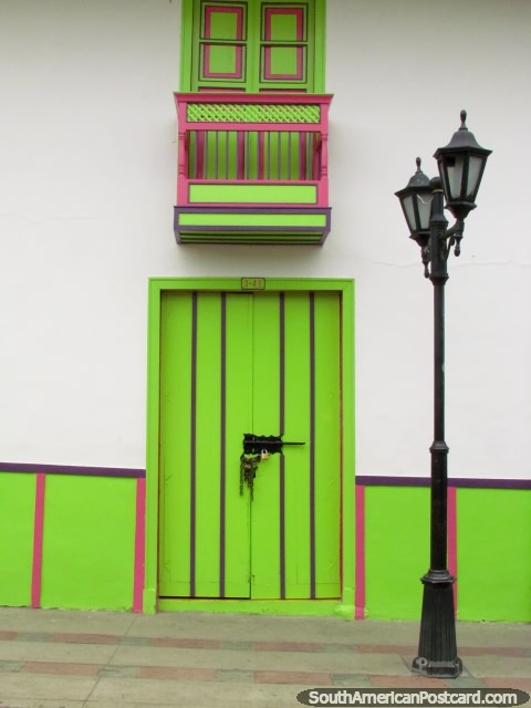 Green and pink windows and balcony, wooden door and streetlamp in Salento. (480x640px). Colombia, South America.