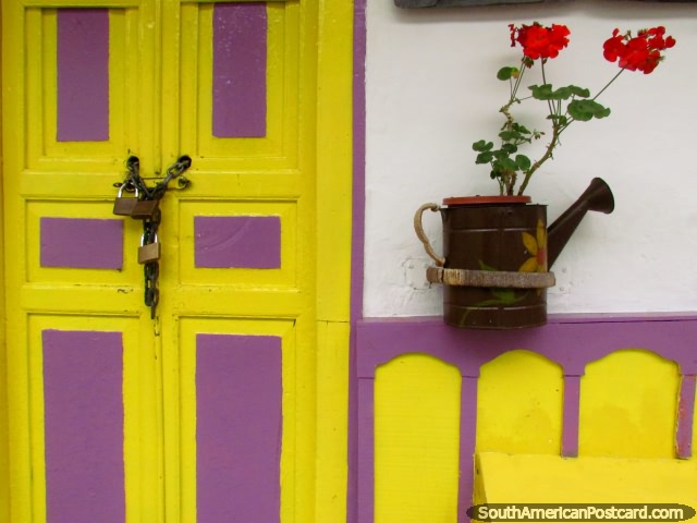 A fachada amarela e purprea com uma rega pode e flores vermelhas em Salento. (640x480px). Colmbia, Amrica do Sul.