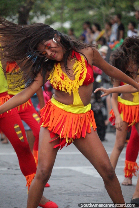 A menina em vermelho, amarelo e cor-de-laranja, dançando como uma mulher possuiu, o Festival do Mar, Santa Marta. (480x720px). Colômbia, América do Sul.