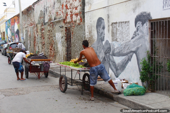 Men get their fruit trolleys ready for a days work in Cartagena on a back street. (720x480px). Colombia, South America.