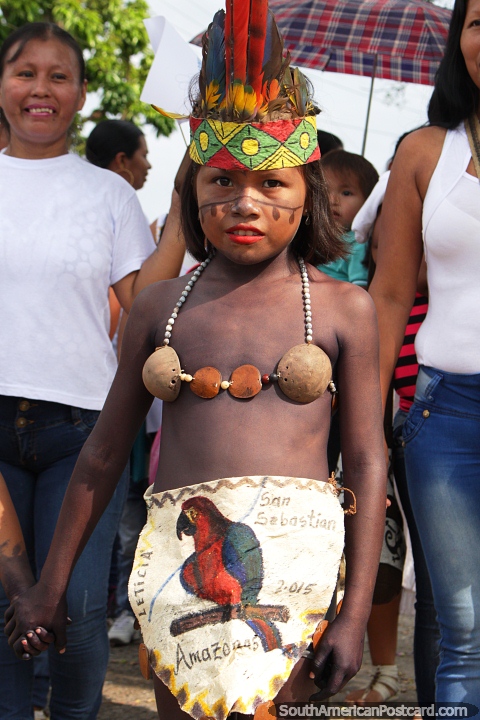 Uma menina de Amazônia de Leticia veste-se da roupa tradicional com penas e colar. (480x720px). Colômbia, América do Sul.