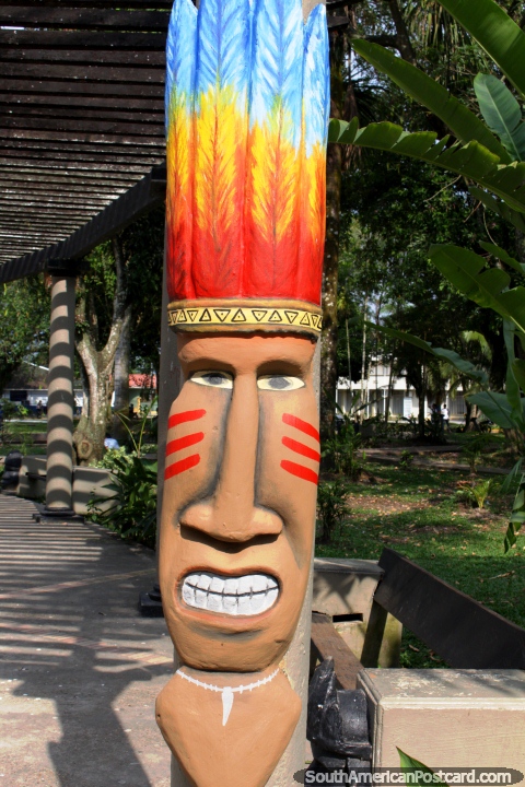 Monumento en el parque en Leticia de una figura con plumas coloridas en su cabeza. (480x720px). Colombia, Sudamerica.