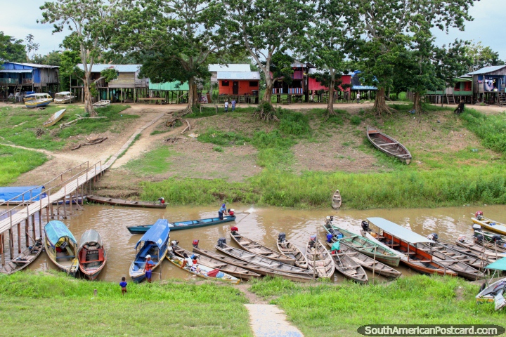 Canoas de rio de madeira, uma ponte de madeira e casas de madeira em pernas de pau, o Amazônia em Leticia. (720x480px). Colômbia, América do Sul.