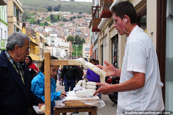 O homem massageia um caramelo gooey regalo saboroso de pr em xcaras, para a venda em Tunja. (720x480px). Colmbia, Amrica do Sul.