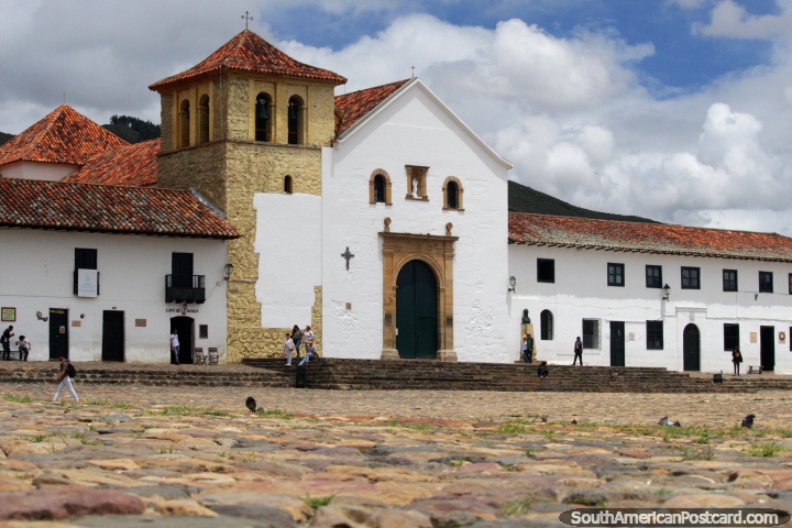 Igreja branca icônica em prefeito de Praça pública em Villa de Leyva, pedras arredondadas e torre. (720x480px). Colômbia, América do Sul.