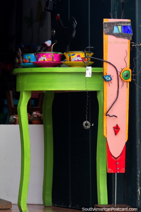 Mesa verde com boliches coloridos e uma cara em uma estante, loja de arte e galeria em Villa de Leyva. (480x720px). Colômbia, América do Sul.