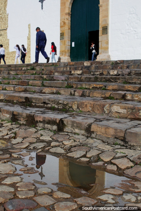Cobblestone stairs lead up to the church door in Villa de Leyva, reflection in the water. (480x720px). Colombia, South America.