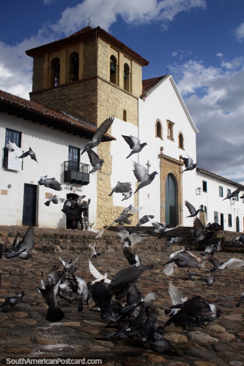 Las palomas vuelan frente a la iglesia en Villa de Leyva, construida entre 1608 y 1665. (480x720px). Colombia, Sudamerica.