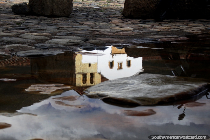 Reflection of the iconic white church and stone tower on the cobblestones of the plaza in Villa de Leyva. (720x480px). Colombia, South America.