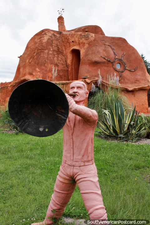Ceramic man blows a horn in front of the Terracotta House in Villa de Leyva. (480x720px). Colombia, South America.