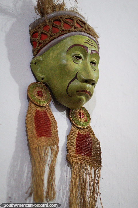 Asian man with earrings, green mask at the museum of Luis Alberto Acuna in Villa de Leyva. (480x720px). Colombia, South America.