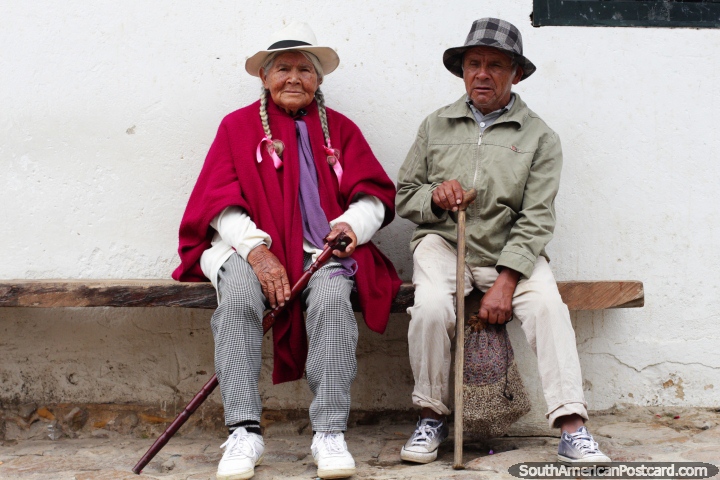 Woman with pink shawl, white hat and pigtails sitting with her husband, elder locals of Villa de Leyva. (720x480px). Colombia, South America.