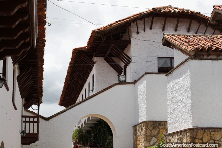 White buildings with red-tiled roofs, archways and wooden balcony, architecture in Guatavita. (720x480px). Colombia, South America.