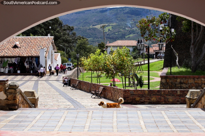 A praça pública de artes e o parque com a grama verde, examine por um arco em Guatavita. (720x480px). Colômbia, América do Sul.