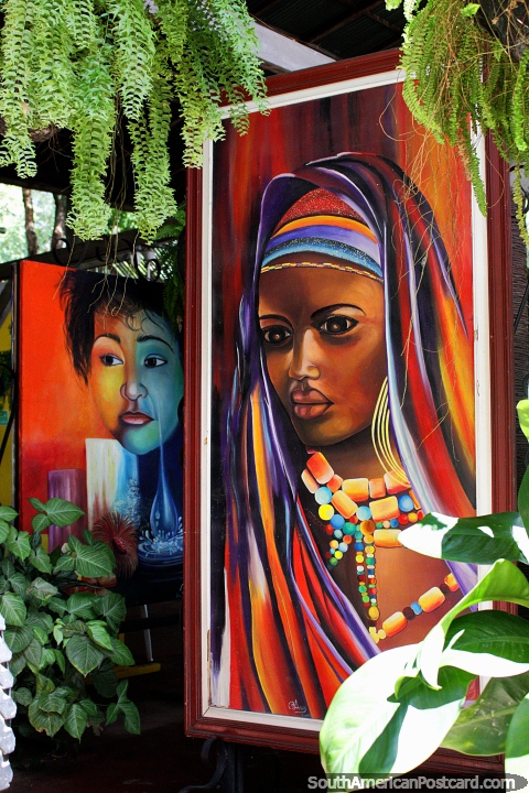 Hermosa mujer con tocado y perlas de colores alrededor de su cuello, pintando en el Restaurante La Maloca, Ricaurte, Girardot. (480x720px). Colombia, Sudamerica.
