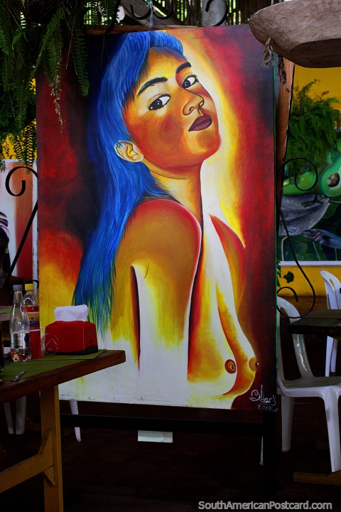 Mujer con cabello azul y un hermoso par de ojos, pintando en el Restaurante La Maloca en Ricaurte cerca de Girardot. (480x720px). Colombia, Sudamerica.