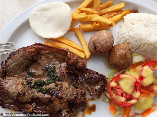 Carne, arroz, patatas, papas fritas, arepa y ensalada para almorzar en Girardot, una comida sencilla. (640x480px). Colombia, Sudamerica.