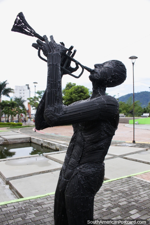 El hombre de hierro toca la trompeta hacia el cielo en el Parque de la Música en Ibagué. (480x720px). Colombia, Sudamerica.