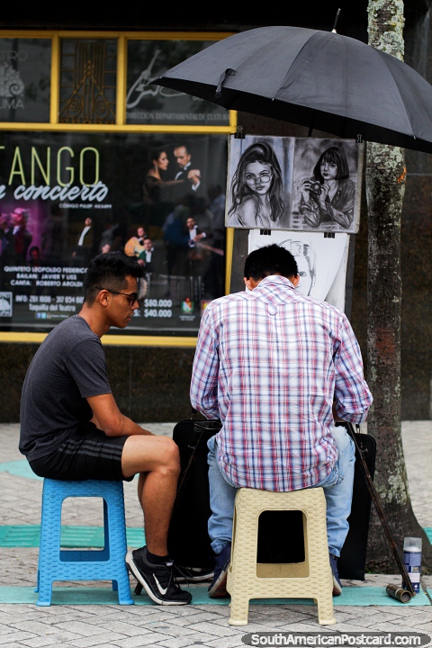 O artista desenha um retrato enquanto um homem espera, divertimento no centro de Ibague. (480x720px). Colmbia, Amrica do Sul.