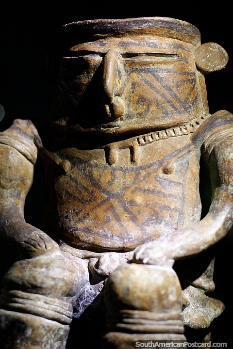 Man sitting in a seat, some of the amazing pottery you see at La Merced Archaeological Museum in Cali. (480x720px). Colombia, South America.