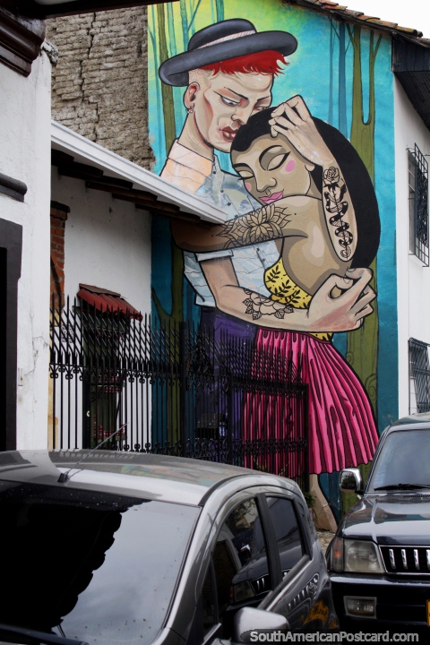 Man and woman with tattoos embrace, amazing street art in Cali. (480x720px). Colombia, South America.