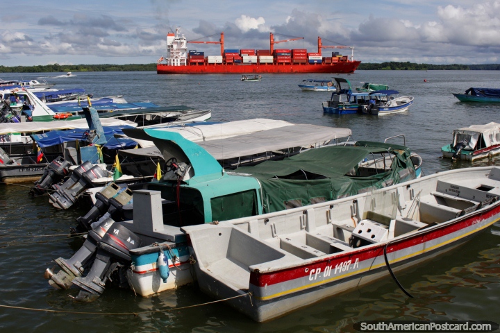 Grande barco de carga vermelho e barcos turïsticos em volta do porto e cais em Buenaventura. (720x480px). Colômbia, América do Sul.