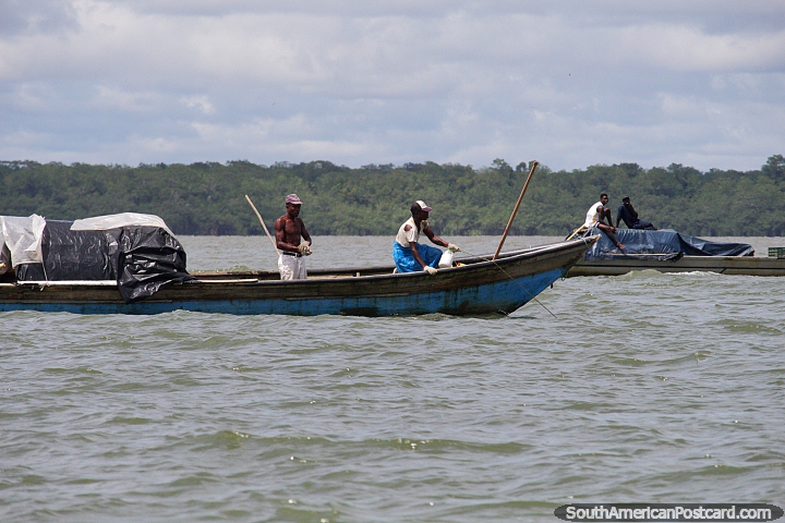 Hombres que transportan carga en barcos frente a la costa de Buenaventura. (720x480px). Colombia, Sudamerica.